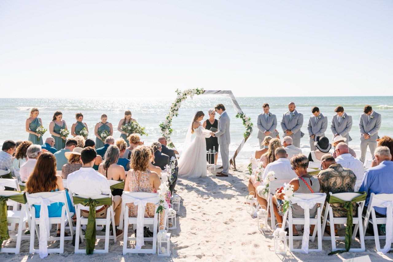 Beachfront ceremony with the wedding party at a hexagon arch on Turtle Beach